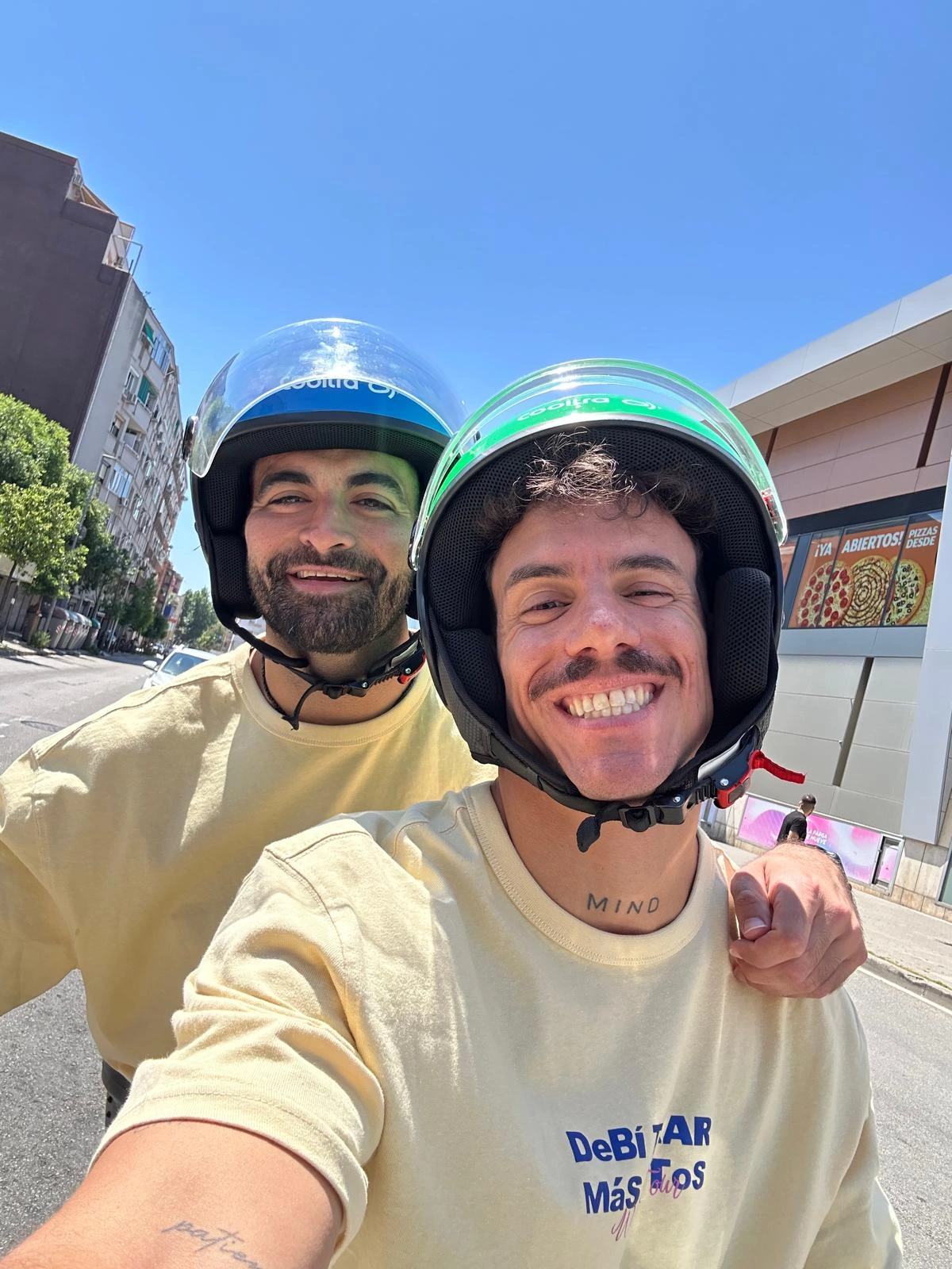 Two friends in scooter helmets taking a selfie